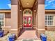 Inviting front entrance features double red doors, columns, and decorative landscaping at 2558 Ballard Ave, Orlando, FL 32833
