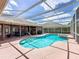 Inviting pool area featuring a screened enclosure, spacious deck, and lush landscaping for ultimate privacy at 2558 Ballard Ave, Orlando, FL 32833