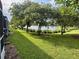 Beautiful backyard view with lush green grass and a serene lake surrounded by trees at 2564 River Landing Dr, Sanford, FL 32771