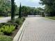 Gated community entrance with brick-paved road and lush landscaping at 2564 River Landing Dr, Sanford, FL 32771