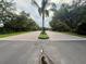 Long driveway with a palm tree in the middle and a gate in the distance at 2564 River Landing Dr, Sanford, FL 32771