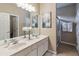 Bright bathroom featuring double sinks, modern fixtures, and a decorative mirror, creating a luxurious space at 2616 Bowring St, Kissimmee, FL 34747