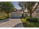 Charming two-story home with a well-manicured lawn, mature trees, and a two-car garage at 2616 Bowring St, Kissimmee, FL 34747