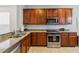 The kitchen is equipped with stainless steel appliances, granite countertops and solid wood cabinetry at 2616 Bowring St, Kissimmee, FL 34747