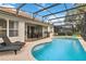 Backyard pool with brick-paved deck, outdoor lounge chairs, and screened enclosure at 2616 Bowring St, Kissimmee, FL 34747