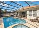 Backyard oasis featuring screened-in pool, spa, and patio with lounge seating at 2616 Bowring St, Kissimmee, FL 34747