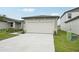 Attached two-car garage with white door and gray trim, complemented by a concrete driveway at 2778 Virginia Pine Dr, Bartow, FL 33830
