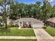 Aerial view of a well-maintained single story home with mature trees and a two-car garage at 2823 Ne 24Th Pl, Ocala, FL 34470