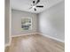 Cozy bedroom with light wood flooring, a ceiling fan, and a large window with natural light at 2823 Ne 24Th Pl, Ocala, FL 34470