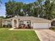 Charming single-story home featuring manicured landscaping and an attached two-car garage at 2823 Ne 24Th Pl, Ocala, FL 34470