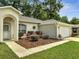 Close-up of a home's entrance showing manicured shrubs and a well maintained lawn at 2823 Ne 24Th Pl, Ocala, FL 34470