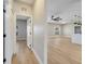 Hallway view leading to an open living area with updated lighting and light wood floors at 2823 Ne 24Th Pl, Ocala, FL 34470