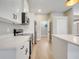 Modern kitchen boasts white cabinetry, stainless steel appliances, and light wood flooring at 2823 Ne 24Th Pl, Ocala, FL 34470