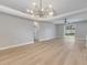 Open-concept living room with hardwood floors, neutral walls, and sliding glass doors at 2823 Ne 24Th Pl, Ocala, FL 34470