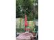 An outdoor sitting area featuring a red table and umbrella, surrounded by lush greenery and privacy walls at 31701 State Road 44 Sr-44, Eustis, FL 32736