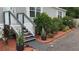 Exterior front stairs with beautiful landscaping, including potted plants and hibiscus bushes at 31701 State Road 44 Sr-44, Eustis, FL 32736