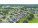 Aerial view showing a community with well-kept lawns, mature trees, and a scenic lake in the background at 31961 Redtail Reserve Blvd, Sorrento, FL 32776