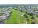Aerial view showcasing a beautiful green golf course surrounded by well-maintained residential homes at 31961 Redtail Reserve Blvd, Sorrento, FL 32776
