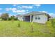 Well-maintained backyard with grass, young trees, and view of a screened patio at 31961 Redtail Reserve Blvd, Sorrento, FL 32776