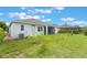 Wide backyard featuring grass, some young trees, the home's rear exterior, and an air conditioning unit at 31961 Redtail Reserve Blvd, Sorrento, FL 32776