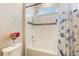 Bathroom with a shower-tub combo featuring a blue and white floral curtain and gray mosaic tile backsplash at 31961 Redtail Reserve Blvd, Sorrento, FL 32776