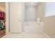 Bright white bathroom featuring a soaking tub with white subway tile and marble flooring at 31961 Redtail Reserve Blvd, Sorrento, FL 32776