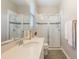 Bathroom with a tiled glass-enclosed shower, sink, and large mirror at 31961 Redtail Reserve Blvd, Sorrento, FL 32776