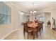 Elegant dining room with a wood table set for six, tile flooring, and views of the living area at 31961 Redtail Reserve Blvd, Sorrento, FL 32776