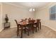 Formal dining room with a wooden table set for six, complemented by neutral paint and crown molding at 31961 Redtail Reserve Blvd, Sorrento, FL 32776