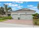 Attractive home featuring well-kept landscaping, a paver driveway, and a convenient two-car garage at 31961 Redtail Reserve Blvd, Sorrento, FL 32776