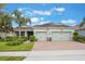 Inviting single-story home with lush landscaping, a two-car garage, and a welcoming brick driveway at 31961 Redtail Reserve Blvd, Sorrento, FL 32776