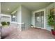 Covered front porch with brick flooring, stone accents, and a view of the home's exterior features at 31961 Redtail Reserve Blvd, Sorrento, FL 32776