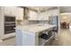 Stylish kitchen featuring a center island with seating, stainless steel appliances, and white cabinetry at 31961 Redtail Reserve Blvd, Sorrento, FL 32776