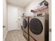 Functional laundry room with new stainless steel washer and dryer and wood-look flooring at 31961 Redtail Reserve Blvd, Sorrento, FL 32776