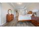 Bright bedroom featuring a tray ceiling, wood floors, and traditional-style furniture at 31961 Redtail Reserve Blvd, Sorrento, FL 32776