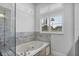 Bright bathroom with a soaking tub, glass shower, tiled walls and natural lighting creating a luxurious feel at 3713 Ocita Dr, Orlando, FL 32837