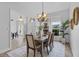 Elegant dining room with a wooden table, chandelier, and views to the foyer, bathed in natural light at 3713 Ocita Dr, Orlando, FL 32837