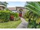 Inviting front entrance with lush landscaping, arched doorway, and a striking red front door at 3713 Ocita Dr, Orlando, FL 32837