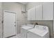 Laundry room with washer and dryer, storage cabinets, and utility sink at 3713 Ocita Dr, Orlando, FL 32837