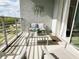 Well-lit balcony with outdoor seating, privacy railing, and views of trees and the sky at 4751 Clock Tower Dr # 304, Kissimmee, FL 34746