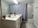Bathroom with a large mirror, white vanity, patterned shower curtain, and tiled floors at 4751 Clock Tower Dr # 304, Kissimmee, FL 34746