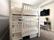 Bright bedroom featuring a sturdy, white bunk bed, a mounted television, and a modern desk space at 4751 Clock Tower Dr # 304, Kissimmee, FL 34746