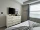 Bright bedroom with white dresser and TV, featuring a large window for natural light at 4751 Clock Tower Dr # 304, Kissimmee, FL 34746