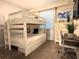 Bright bedroom featuring white bunk beds, a modern desk, and soft natural light from the window at 4751 Clock Tower Dr # 304, Kissimmee, FL 34746