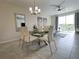 Dining area featuring a glass table, modern lighting, and access to an outdoor balcony at 4751 Clock Tower Dr # 304, Kissimmee, FL 34746
