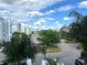 Scenic view of the community with lush landscaping, mature palm trees, and blue skies at 4751 Clock Tower Dr # 304, Kissimmee, FL 34746
