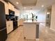 Modern kitchen featuring white cabinets, a center island, tiled floors and stainless steel appliances at 4751 Clock Tower Dr # 304, Kissimmee, FL 34746