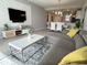 Open-concept living room with modern furnishings, TV, dining area, and stylish decor at 4751 Clock Tower Dr # 304, Kissimmee, FL 34746