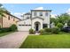 Beautiful two-story white brick home with an attached garage, manicured lawn, and inviting front garden at 528 Greely St, Orlando, FL 32804