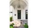 Charming front door with modern light fixture, brick archway, and neutral-toned tile walkway at 528 Greely St, Orlando, FL 32804